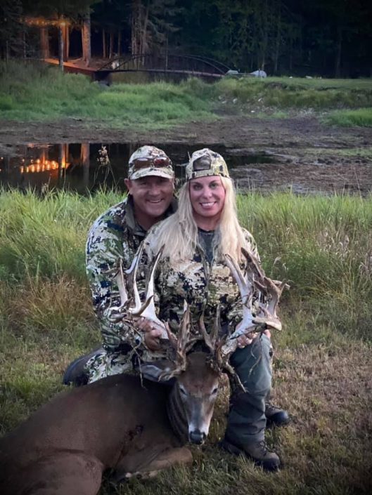 man and woman with buck kill