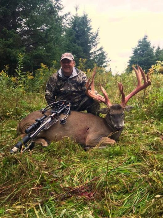 a whitetail hunter shows off his trophy buck 