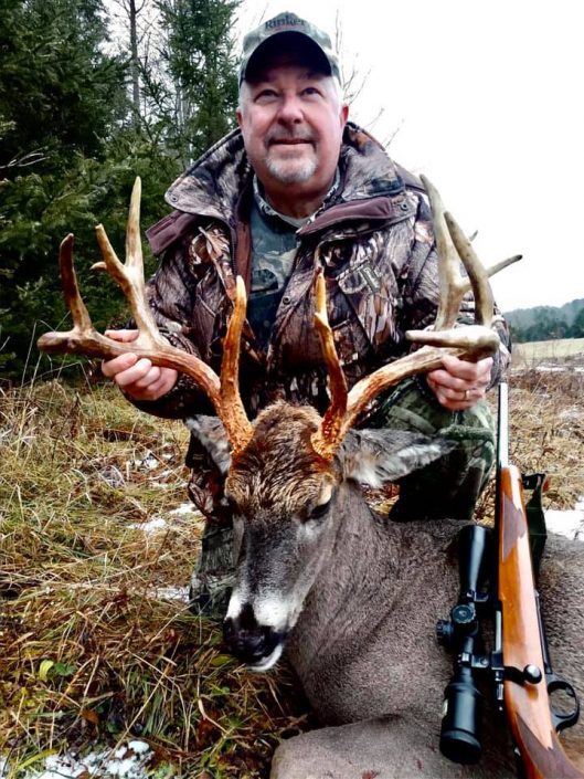 man with deer kill
