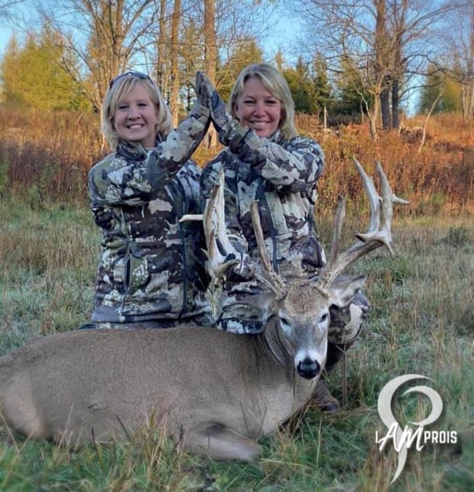 two women posing with buck